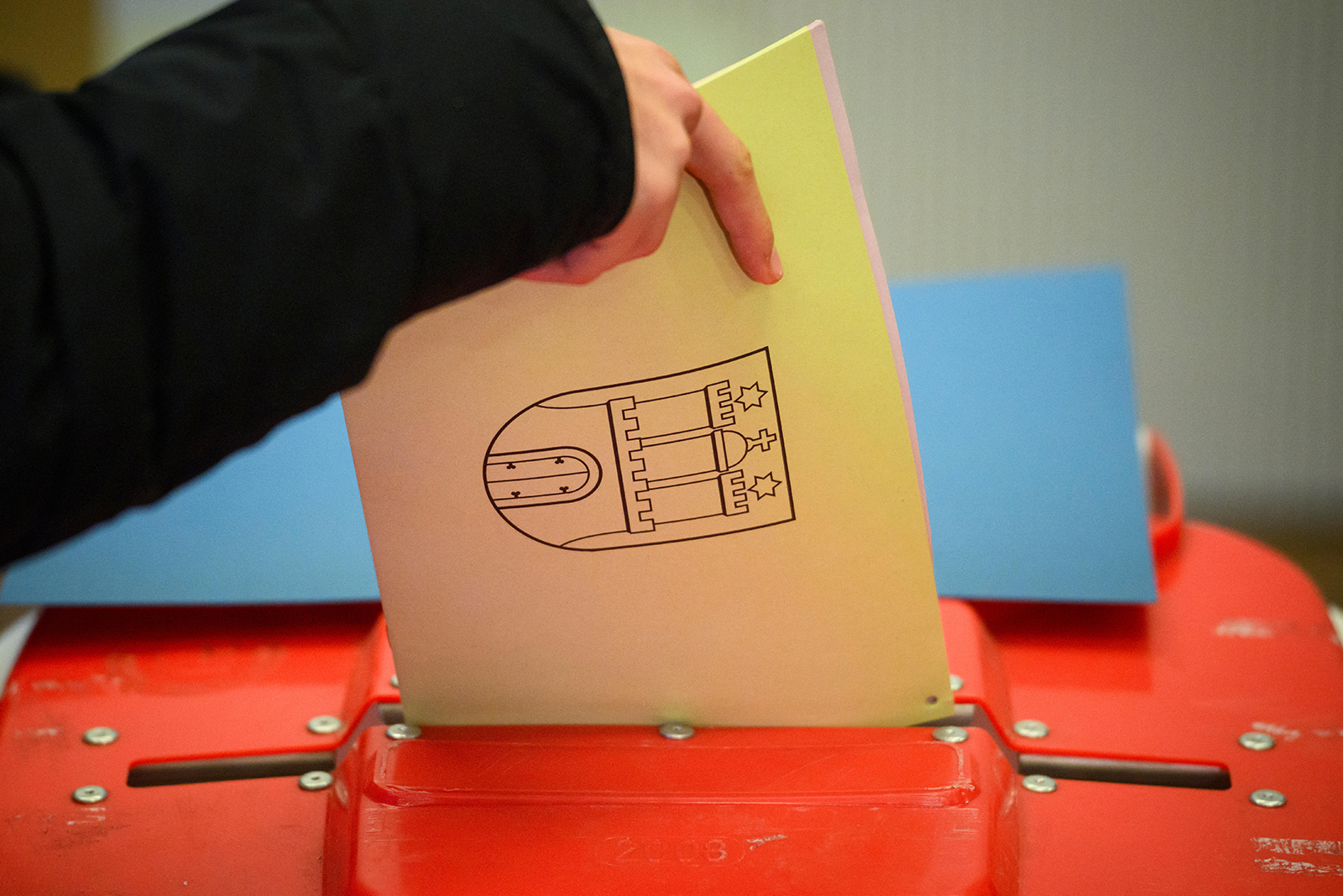 A voter casts a ballot paper with the coat of arms of the city of Hamburg into an urn at a polling station for the state parliament elections in Hamburg on March 2, 2025. 